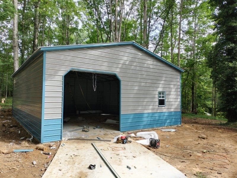 A garage that is being built in the woods.