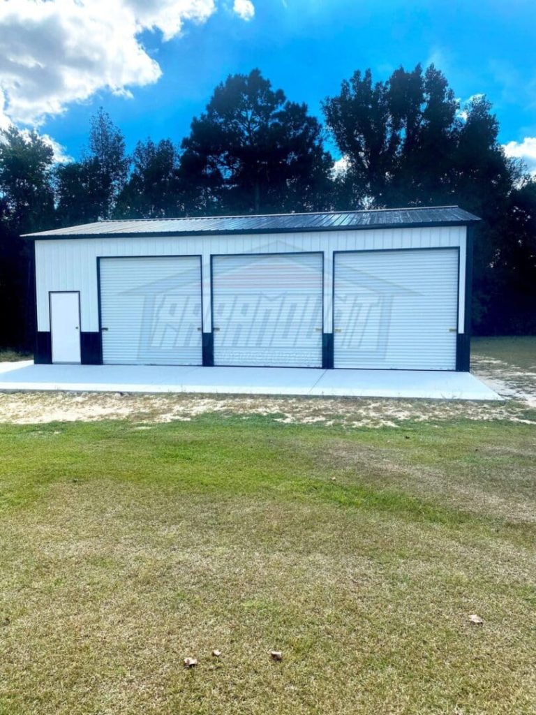 A white building with three doors on the side of it.