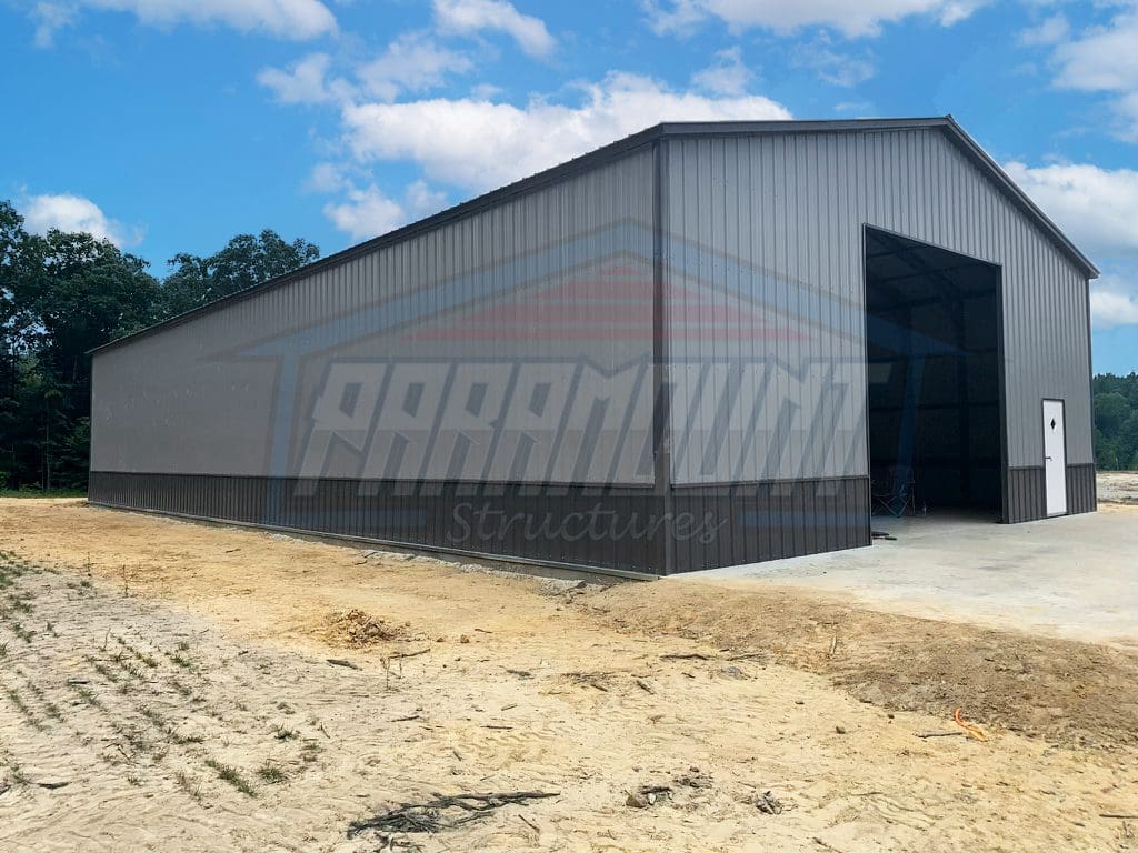 A large building with a metal roof and a concrete base.